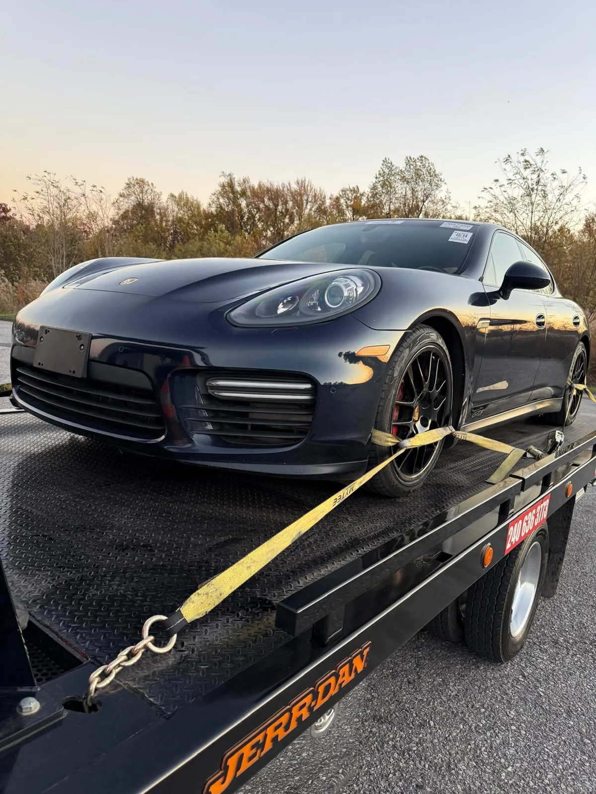 A passenger car secured on a flatbed during transport